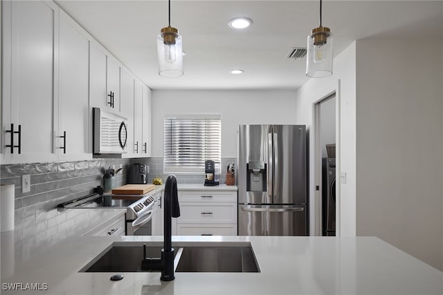 kitchen featuring pendant lighting, sink, white cabinetry, and appliances with stainless steel finishes