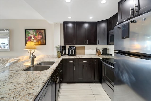 kitchen featuring light tile patterned floors, light stone countertops, stainless steel appliances, and sink