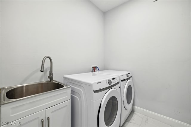 laundry area with separate washer and dryer, cabinets, and sink