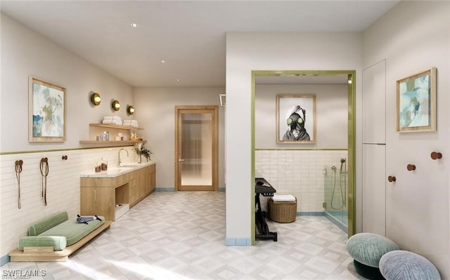 bathroom with vanity, tile walls, and walk in shower