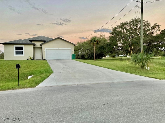 view of front of property featuring a garage and a lawn