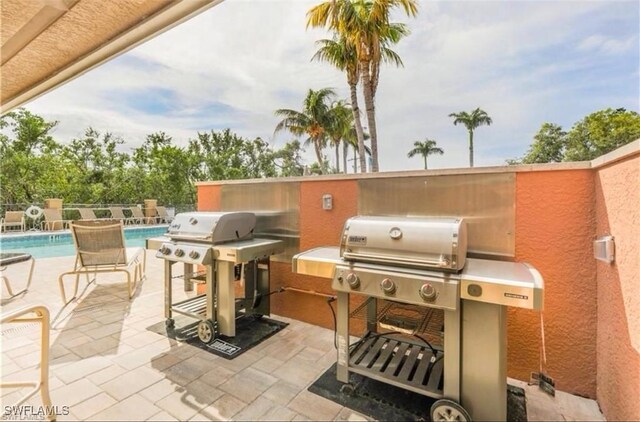 view of patio / terrace featuring a community pool and grilling area