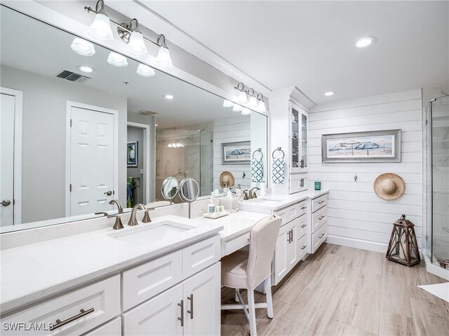 bathroom with vanity, hardwood / wood-style floors, wooden walls, and walk in shower