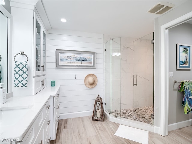 bathroom with a shower with shower door, vanity, and hardwood / wood-style flooring