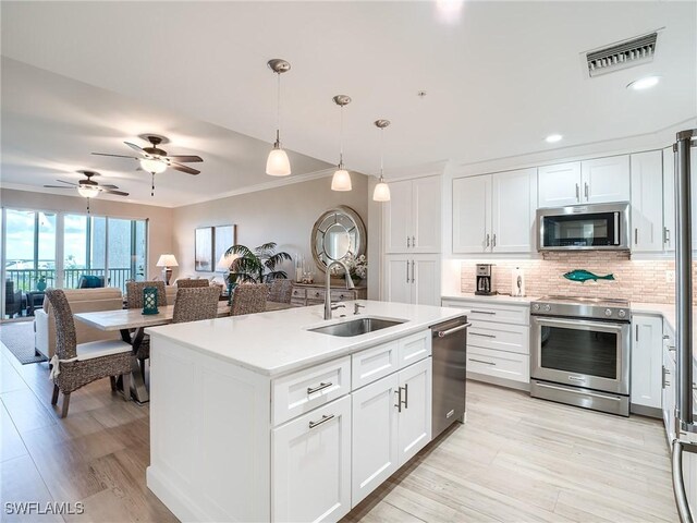 kitchen with white cabinets, decorative light fixtures, stainless steel appliances, sink, and ceiling fan