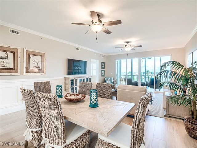 dining room with light wood-type flooring, ornamental molding, and ceiling fan