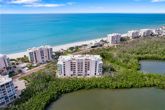 birds eye view of property with a water view and a beach view