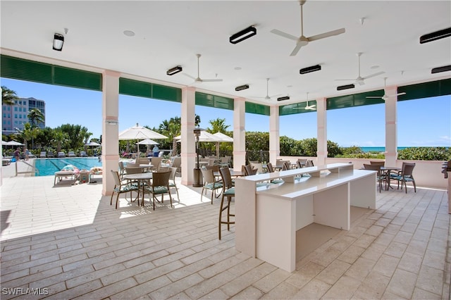 view of patio featuring ceiling fan and a community pool