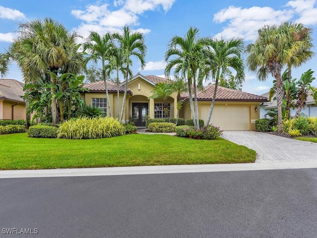 mediterranean / spanish home with a front yard and a garage