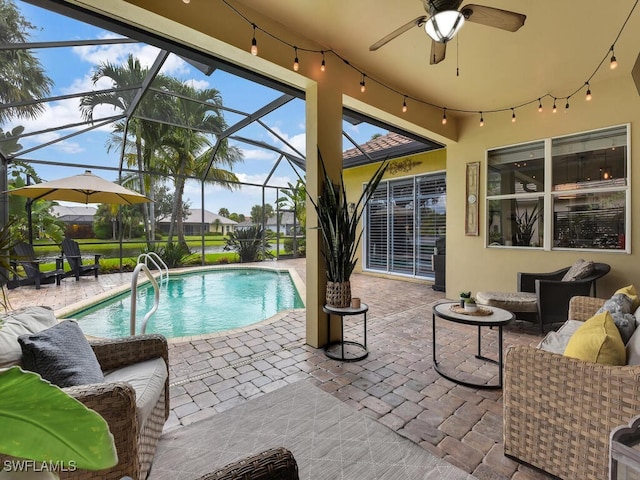 view of swimming pool featuring ceiling fan, glass enclosure, and a patio area