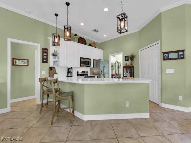 kitchen with white cabinets, kitchen peninsula, pendant lighting, stainless steel appliances, and ornamental molding