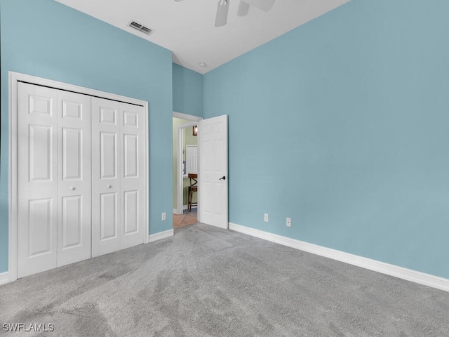 unfurnished bedroom featuring ceiling fan, a closet, and carpet