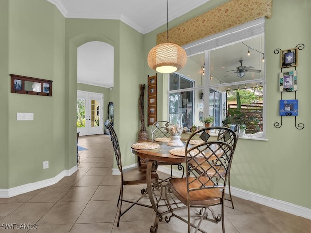 tiled dining room featuring ornamental molding, ceiling fan, and a wealth of natural light