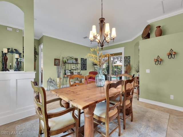 tiled dining room with a notable chandelier and crown molding