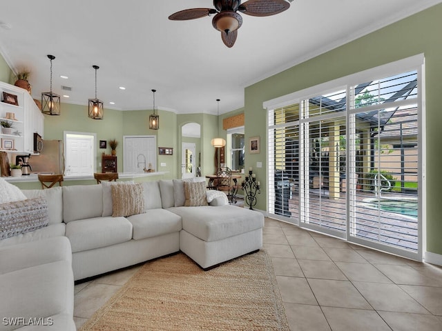 tiled living room with ornamental molding and ceiling fan