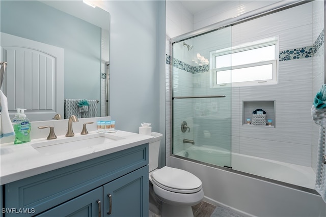 full bathroom featuring shower / bath combination with glass door, vanity, and toilet