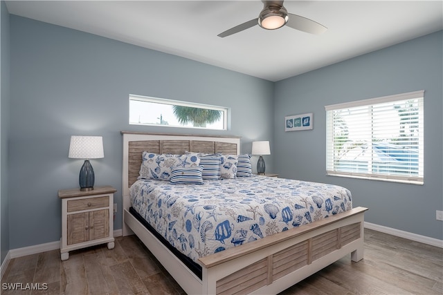 bedroom with ceiling fan, hardwood / wood-style floors, and multiple windows