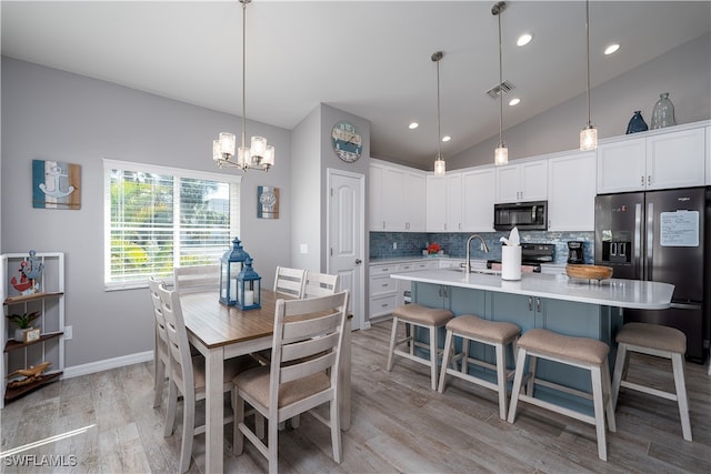 interior space with lofted ceiling, an inviting chandelier, light hardwood / wood-style flooring, and sink