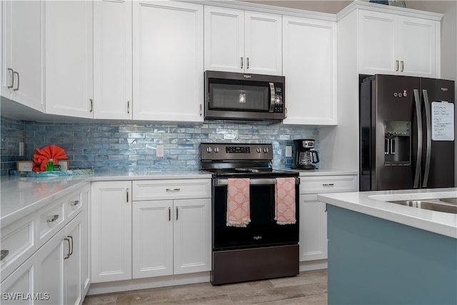 kitchen with light wood-type flooring, backsplash, white cabinetry, and stainless steel appliances