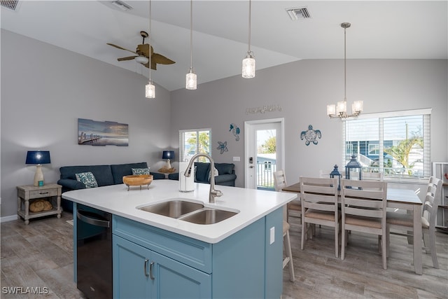 kitchen featuring vaulted ceiling, ceiling fan with notable chandelier, a kitchen island with sink, hardwood / wood-style floors, and sink