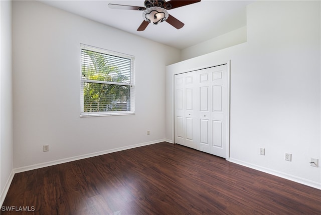 unfurnished bedroom with dark wood-type flooring, a closet, and ceiling fan