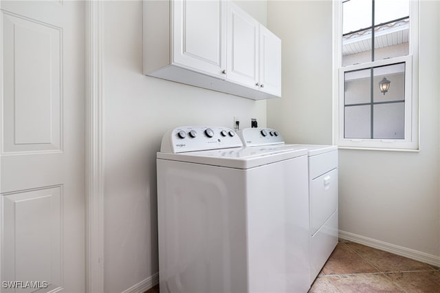 clothes washing area featuring separate washer and dryer, cabinets, and light tile patterned flooring