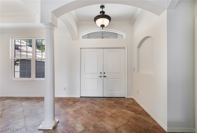 entryway with ornamental molding and decorative columns