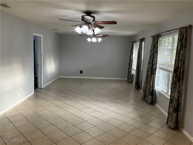 tiled spare room with ceiling fan