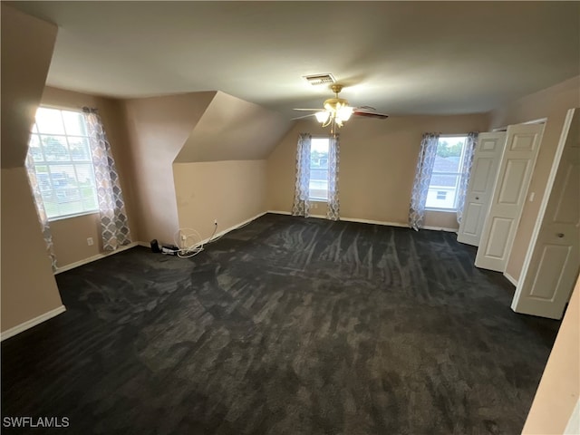 additional living space featuring lofted ceiling, dark carpet, and ceiling fan