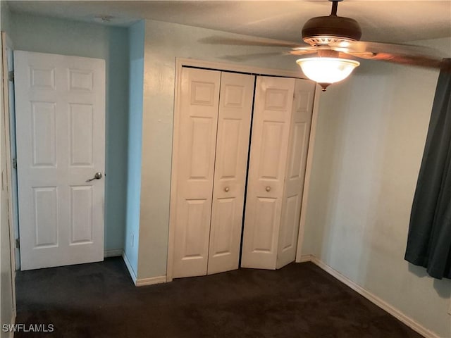 804 Yvonne Ave N, Lehigh Acres, FL 33971 - unfurnished bedroom with dark carpet, baseboards, a closet, and ceiling fan