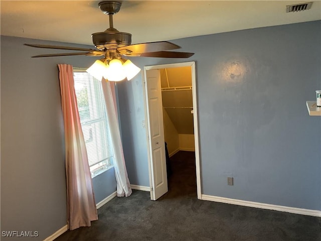 804 Yvonne Ave N, Lehigh Acres, FL 33971 - unfurnished bedroom featuring multiple windows, dark carpet, baseboards, and a ceiling fan