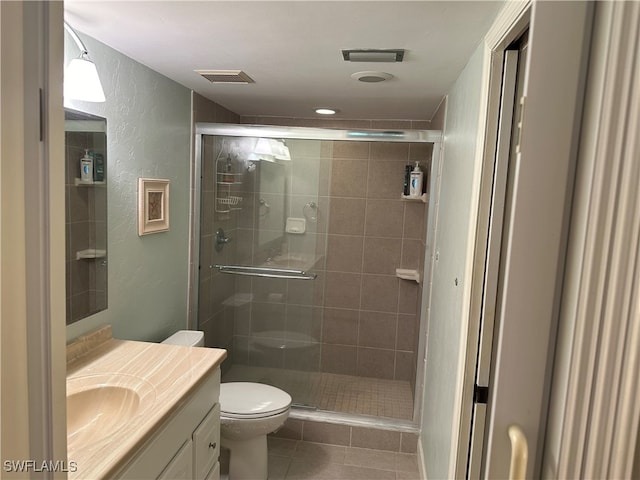 bathroom with tile patterned floors, walk in shower, toilet, and vanity