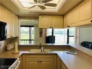 kitchen featuring light brown cabinets, kitchen peninsula, sink, and ceiling fan