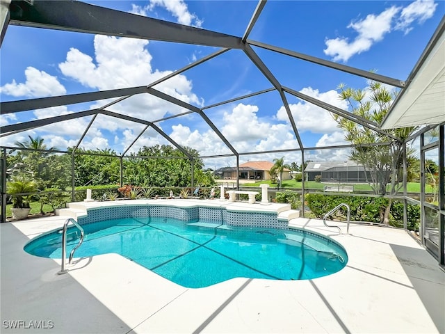 view of pool with a jacuzzi, a patio area, and a lanai