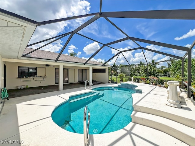 view of pool featuring a patio area, glass enclosure, and ceiling fan