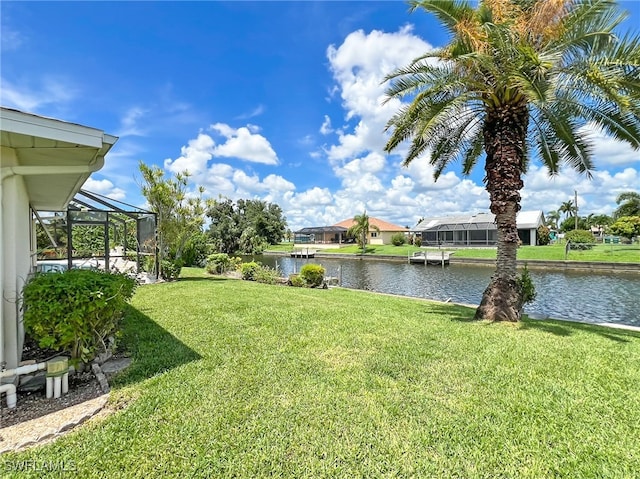 view of yard featuring a water view and glass enclosure