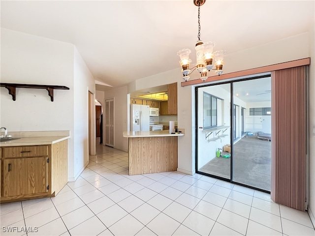 kitchen featuring hanging light fixtures, sink, light tile patterned floors, a chandelier, and white appliances