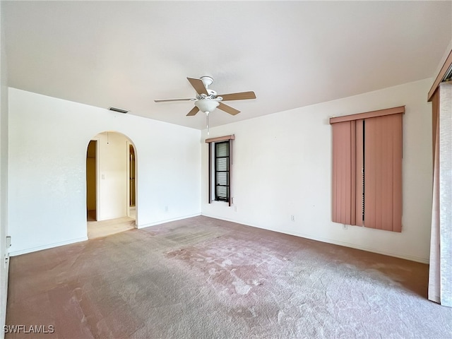 empty room featuring ceiling fan and light colored carpet