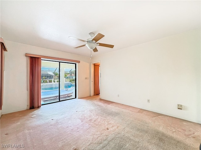 spare room featuring light carpet and ceiling fan