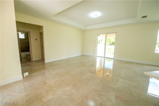 spare room with a tray ceiling