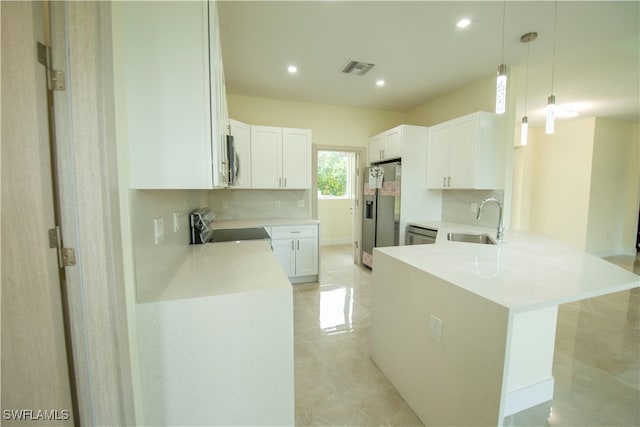 kitchen with white cabinets, hanging light fixtures, sink, kitchen peninsula, and stainless steel appliances