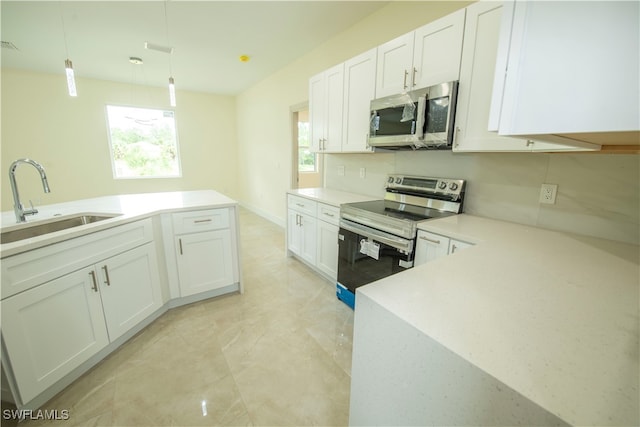 kitchen with white cabinets, stainless steel appliances, hanging light fixtures, and a wealth of natural light