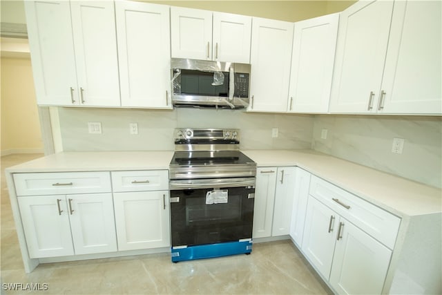 kitchen featuring decorative backsplash, white cabinetry, and appliances with stainless steel finishes