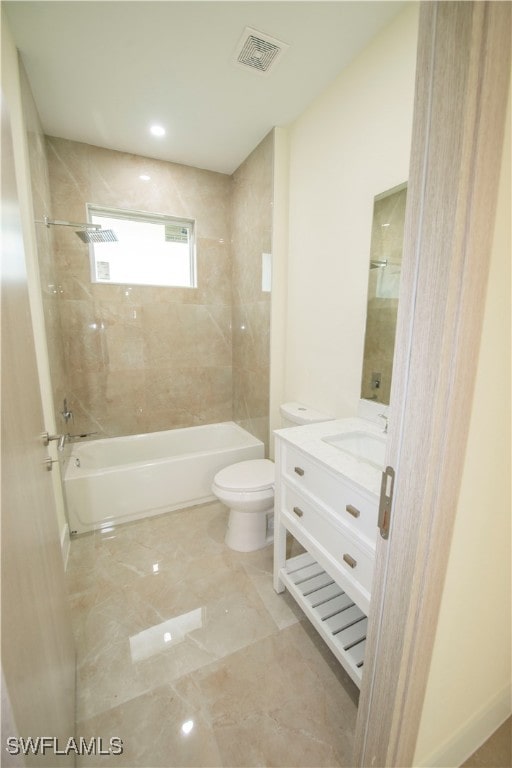 full bathroom featuring tiled shower / bath, vanity, and toilet