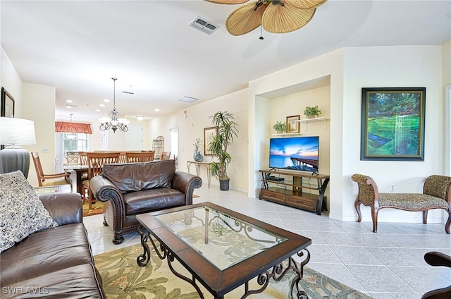 living room with ceiling fan with notable chandelier and light tile patterned floors