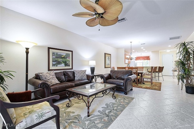 living room featuring ceiling fan with notable chandelier