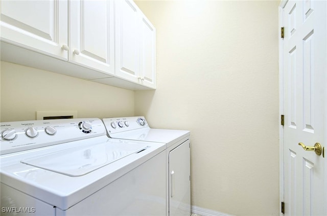 laundry room featuring washing machine and dryer and cabinets