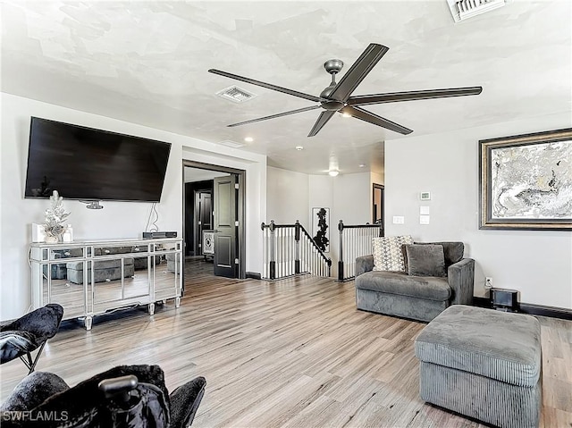 living room with ceiling fan and light hardwood / wood-style flooring