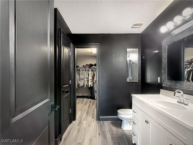 bathroom featuring toilet, vanity, and hardwood / wood-style flooring