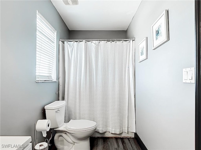 bathroom featuring toilet, shower / tub combo, and hardwood / wood-style floors